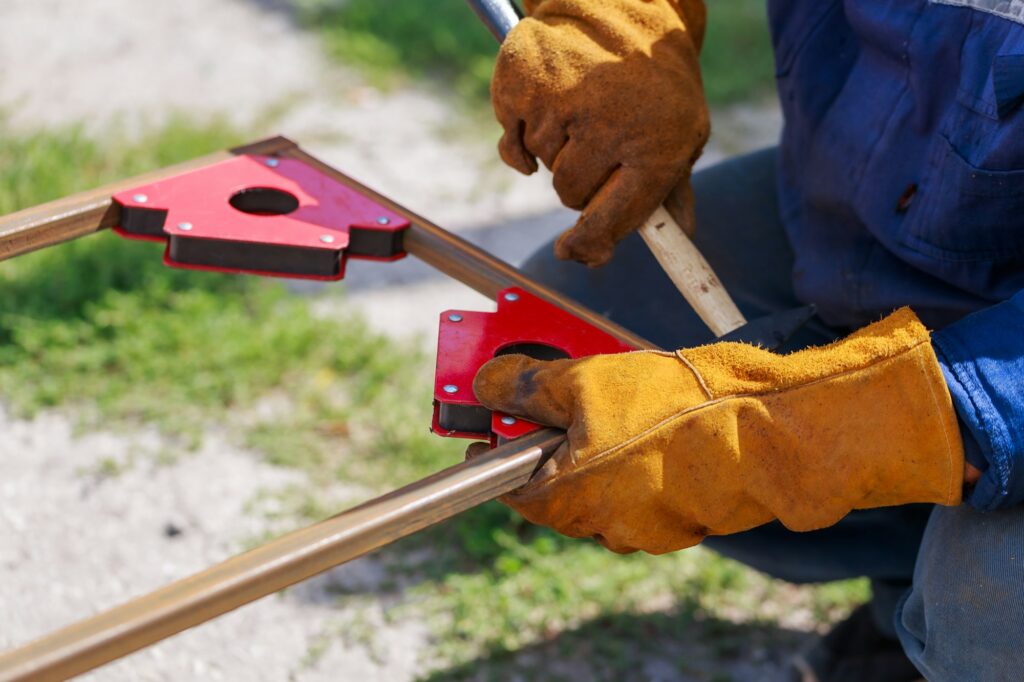 Working Auxiliary Tools in the Hands of a Worker Welder. Using a Magnetic Welding